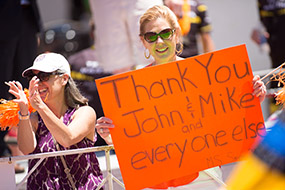 Supporter hold sign that reads Thank You John and Mike and Everyone Else